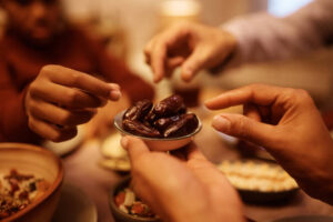 close up of muslim family eating dates during iftar meal at dining table.